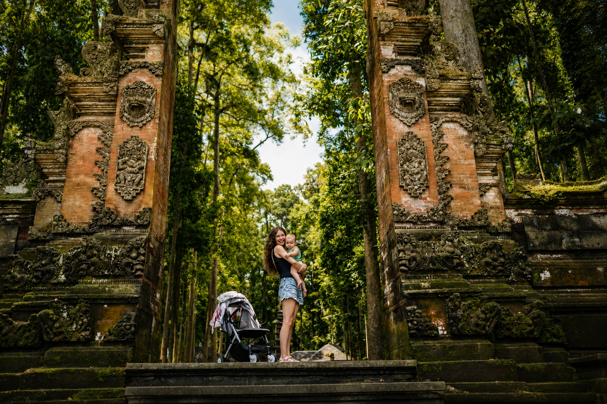 Ibu membawa bayi saat mengunjungi gerbang tradisional di Bali