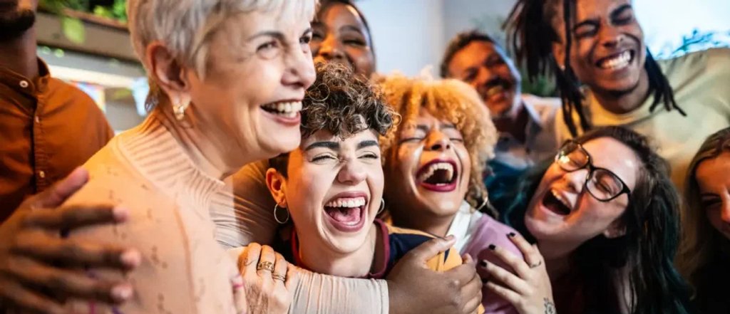 Grupo de personas reunidas y sonriendo en un encuentro social.