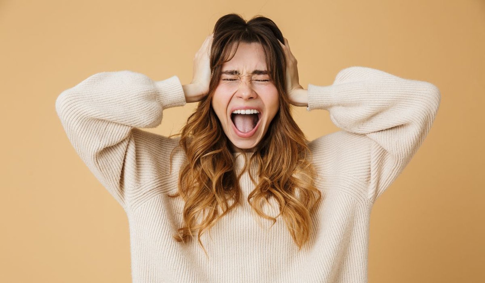 Joven cansada y frustrada por la hiperexigencia emocional contemporánea, con la cabeza apoyada en la mano.