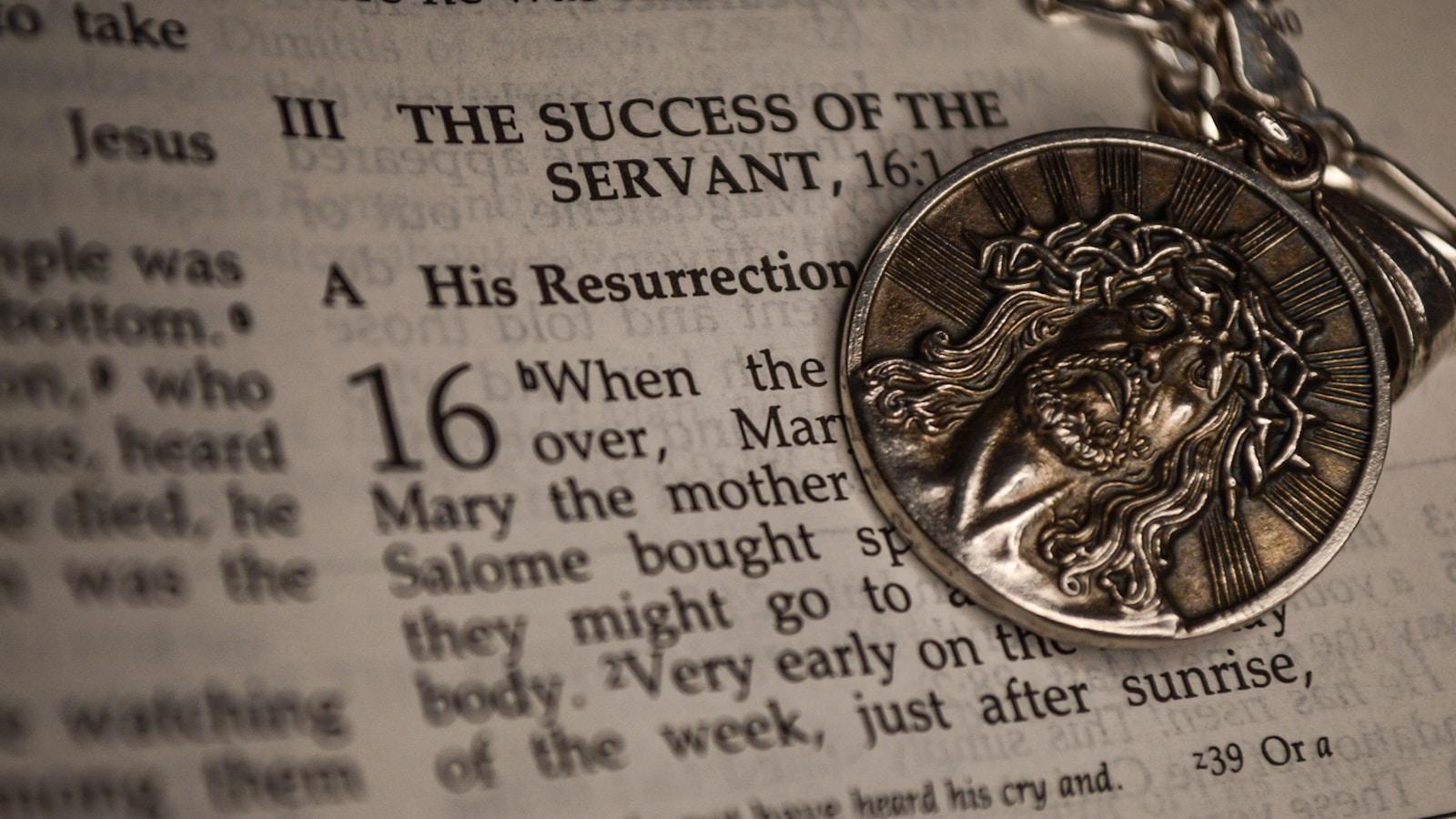 Medalha religiosa com o rosto de Cristo sobre a página de uma Bíblia