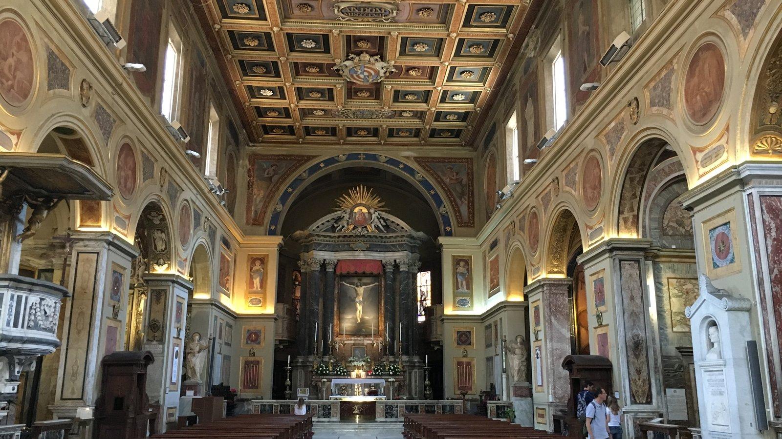 Nave de uma basílica romana, com bancos, colunas e altar-mor ao fundo