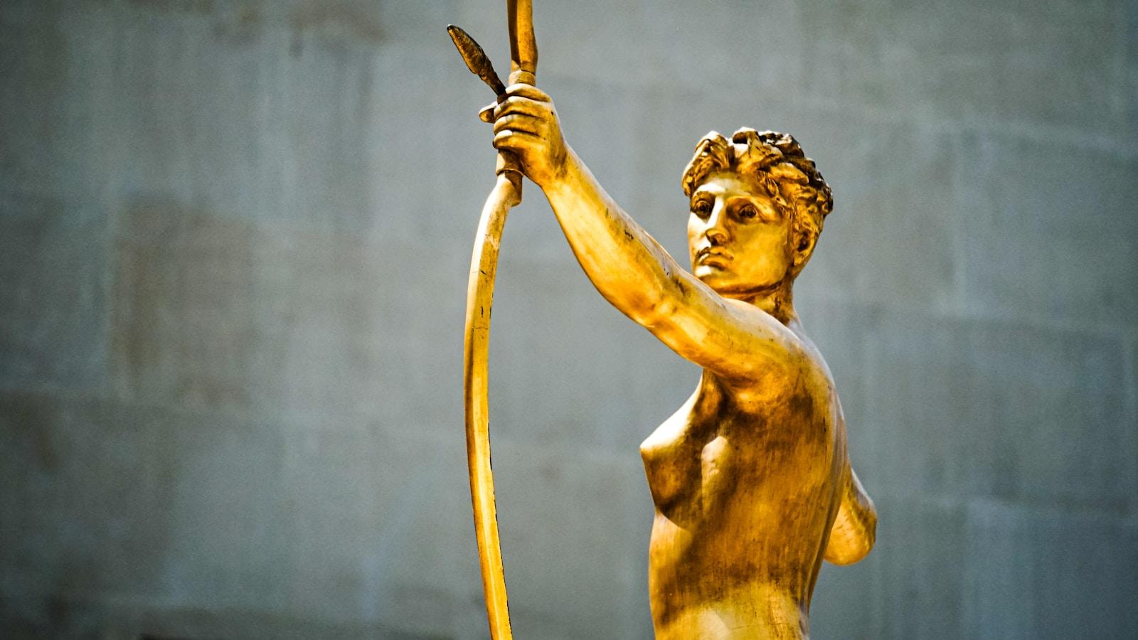 Estátua dourada de uma figura humana segurando um arco