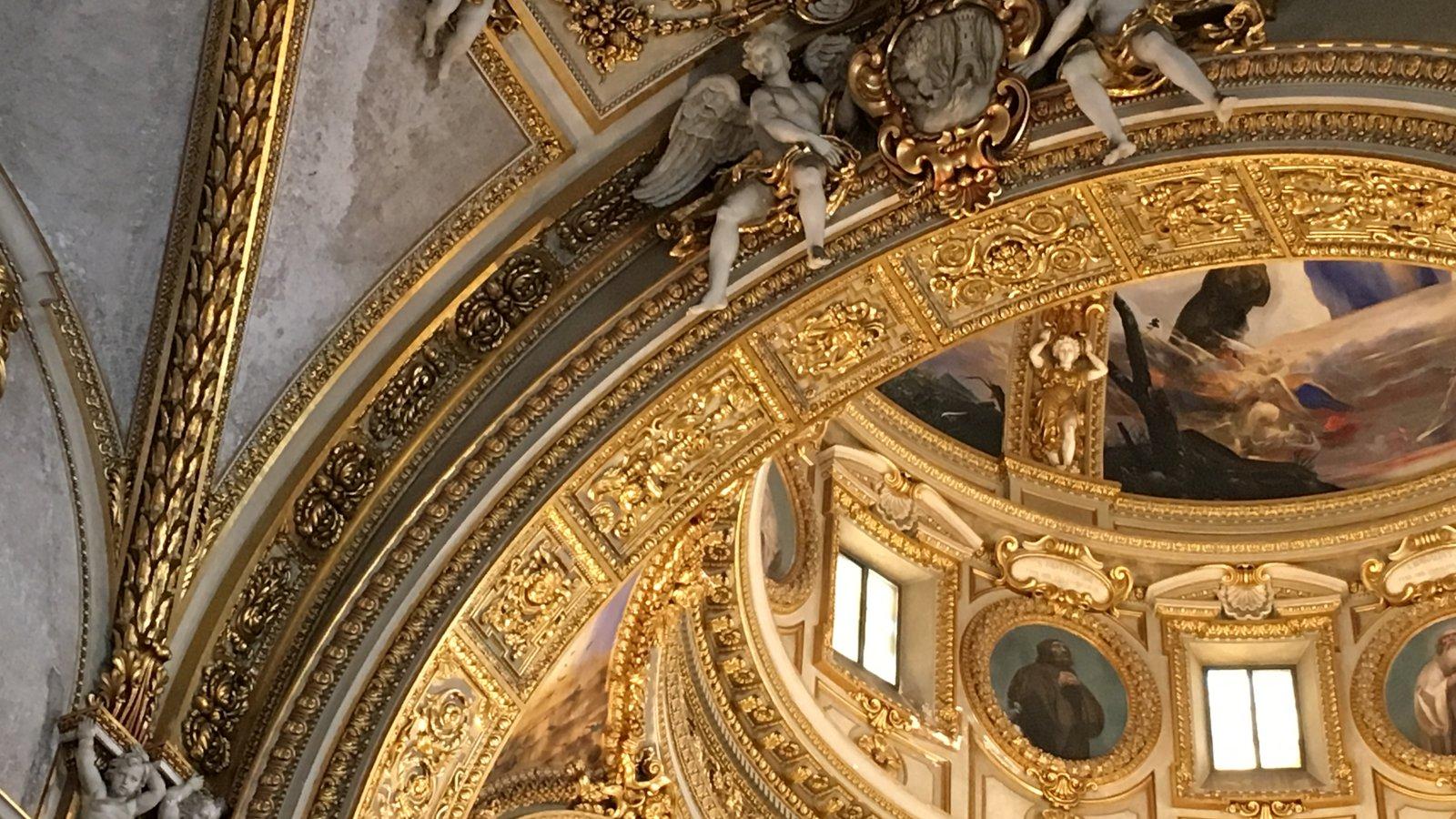 Detalhe de teto dourado com anjos esculpidos numa igreja barroca