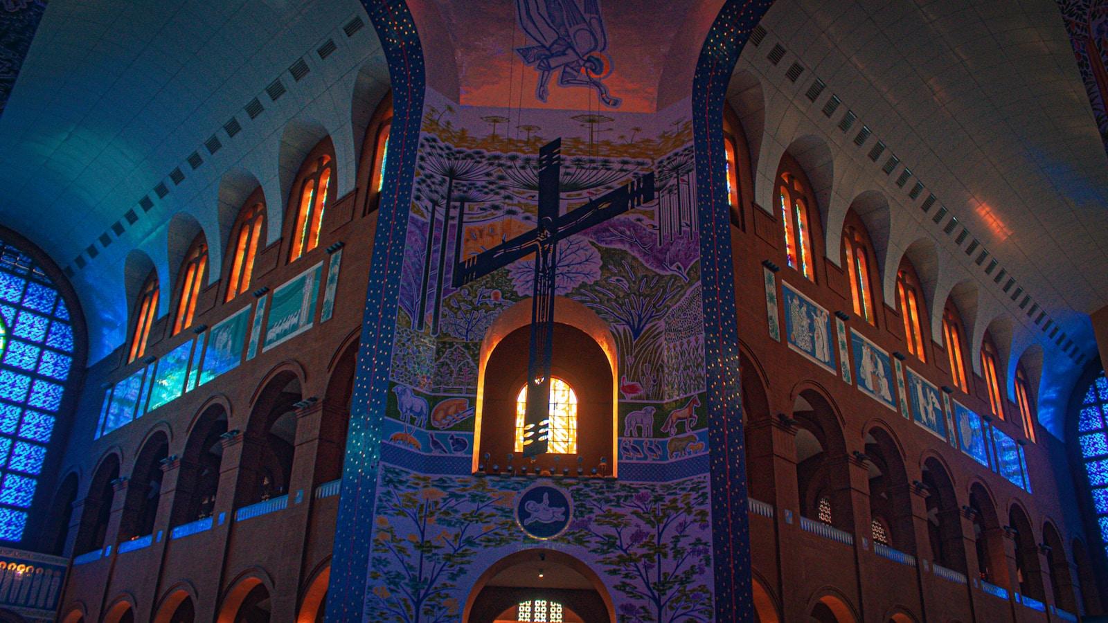 Interior da Basílica de Aparecida, com a grande cruz e os vitrais coloridos iluminados