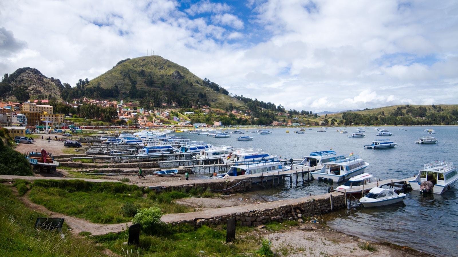 Porto de Copacabana, na Bolívia, com barcos no lago Titicaca e um morro ao fundo
