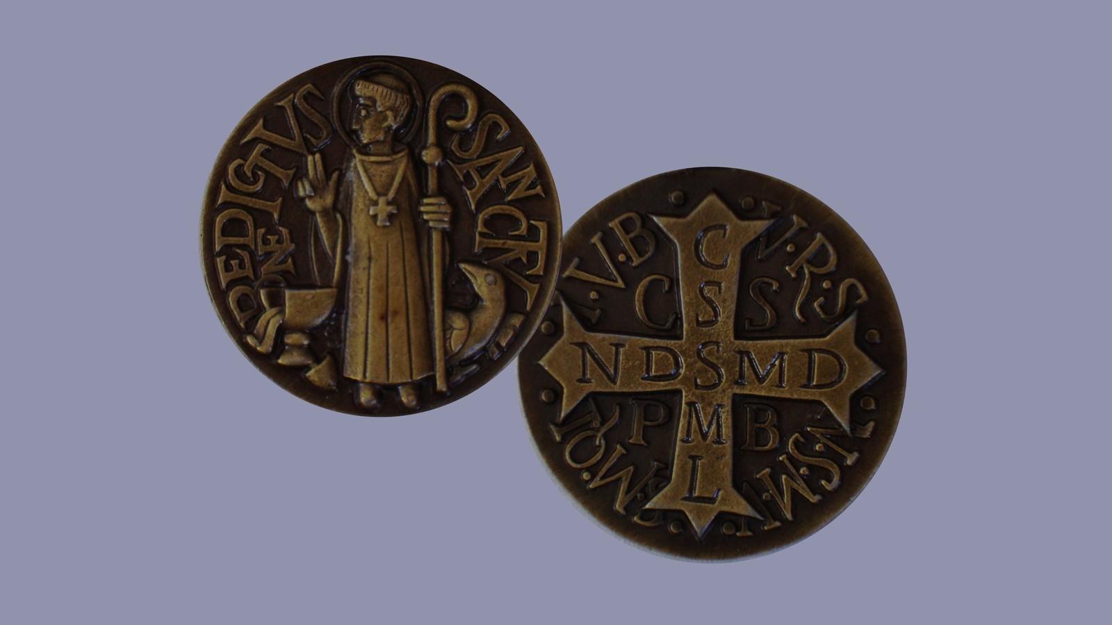 Medalha de São Bento em bronze, frente e verso: o santo com o báculo, o cálice e o corvo, e a cruz com as letras