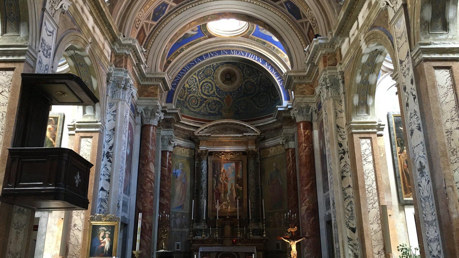Altar-mor em mármore sob um arco decorado, numa igreja