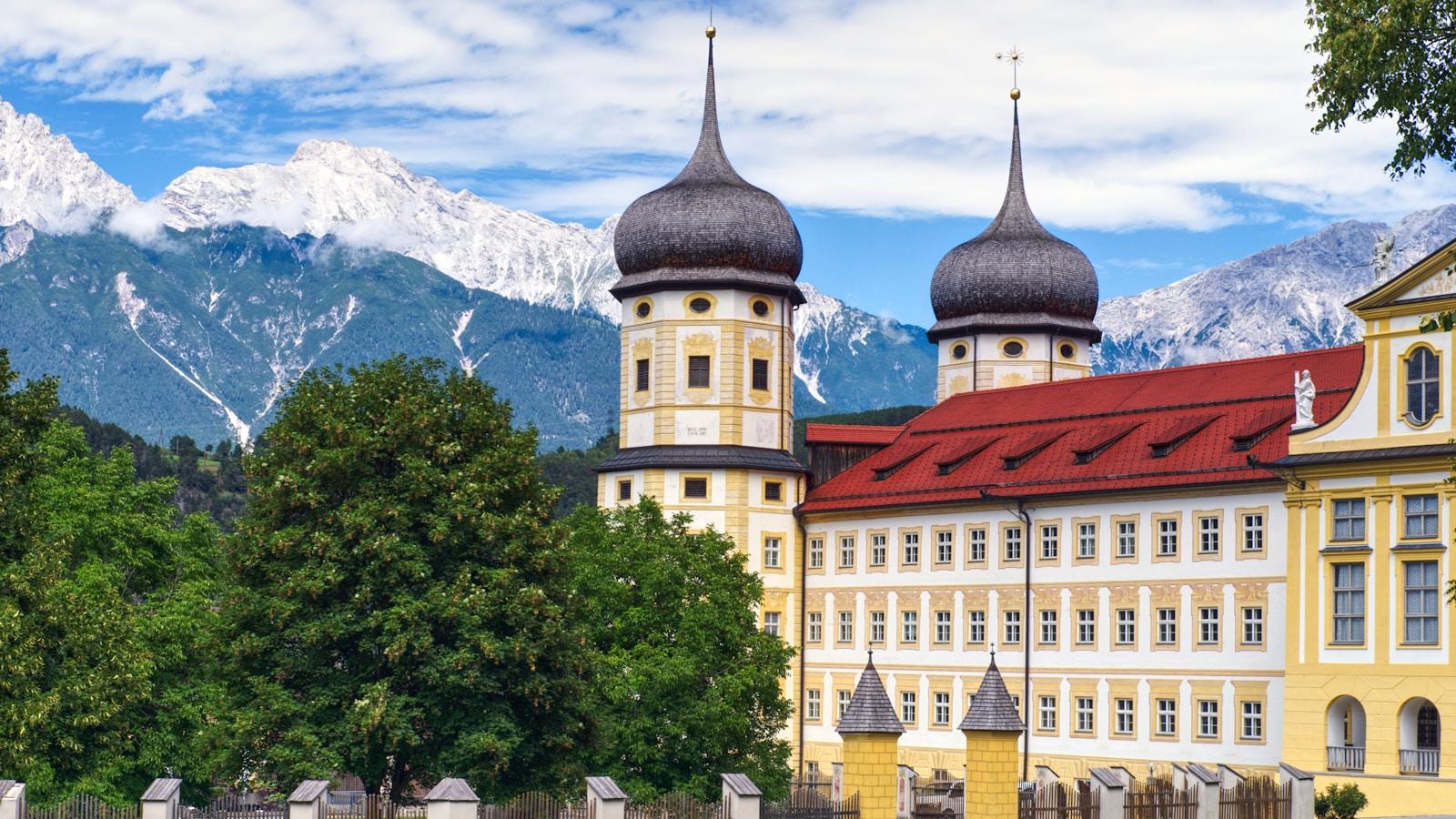 Abadia cisterciense de Stams, na Áustria, com suas torres bulbosas e as montanhas ao fundo