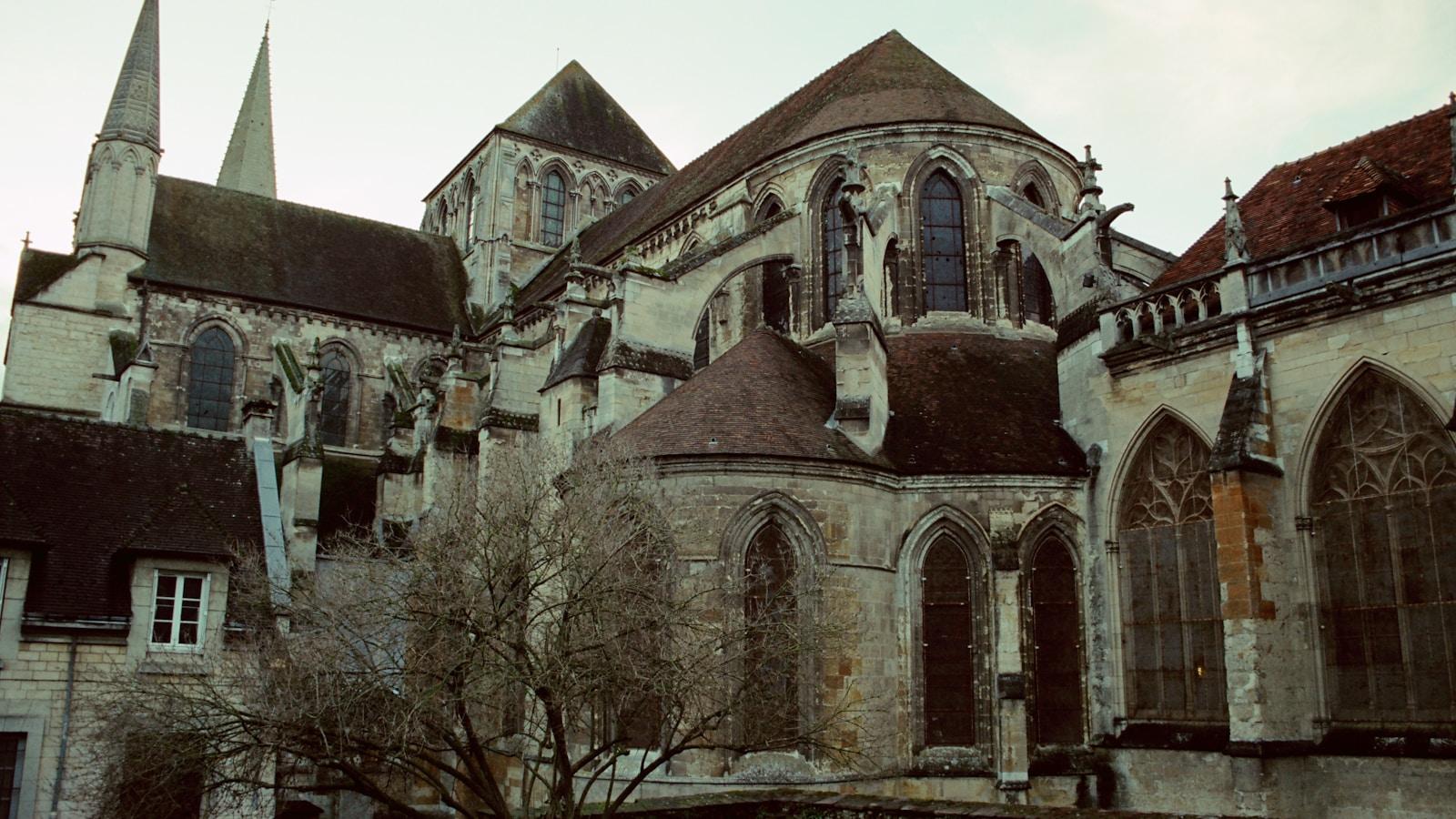 Igreja gótica de pedra com torres pontiagudas e vitrais, em Lisieux