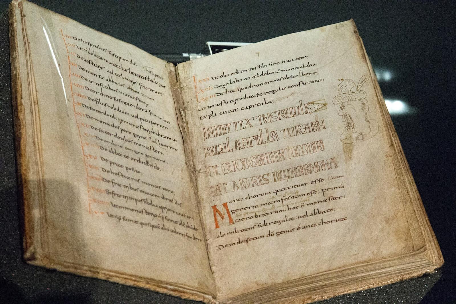 Manuscrito medieval da Regra de São Bento aberto na página do "Incipit textus Regulae".