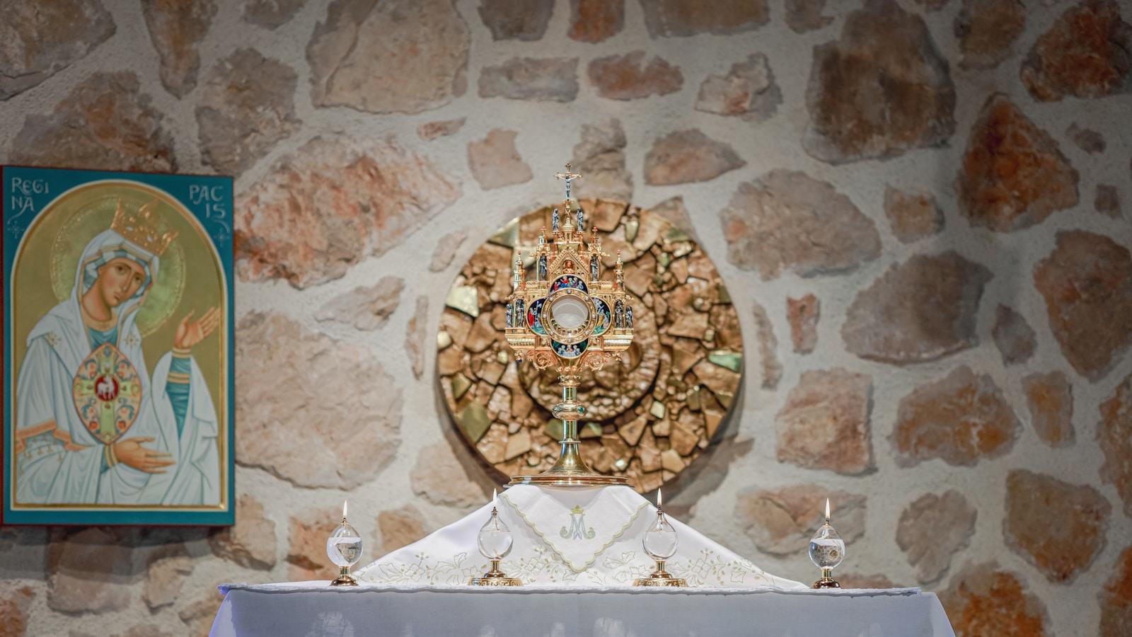 Altar de pedra com ostensório ao centro e ícone de Nossa Senhora à esquerda