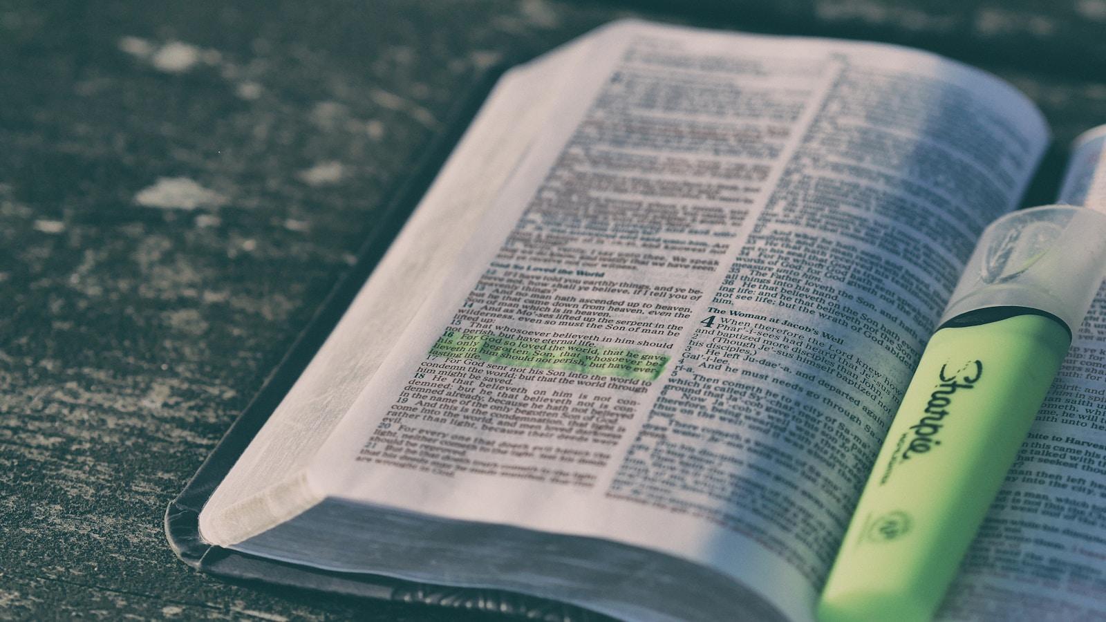 Bíblia aberta com um versículo destacado em verde e um marcador ao lado