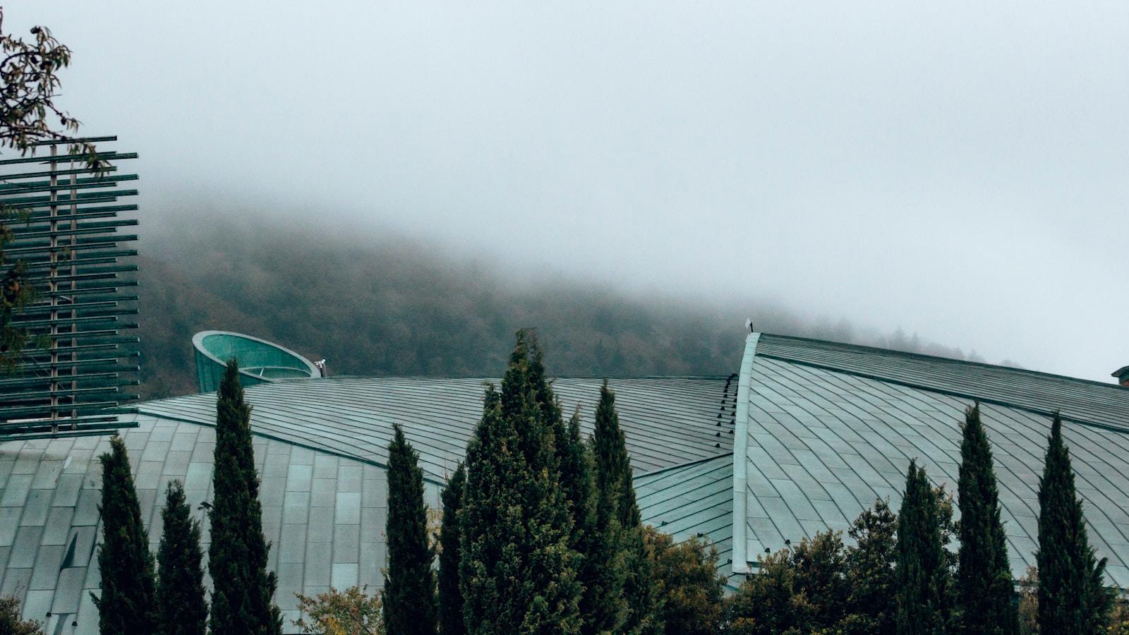 Coberturas de cobre da igreja de São Pio, em San Giovanni Rotondo, entre ciprestes e neblina