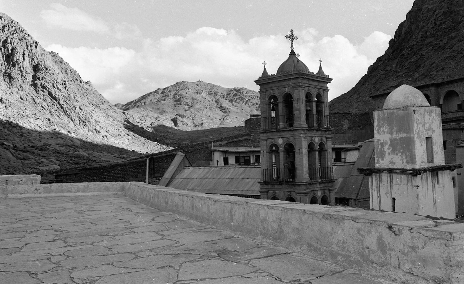 A torre sineira do Mosteiro de Santa Catarina entre as montanhas do Sinai, em preto e branco.