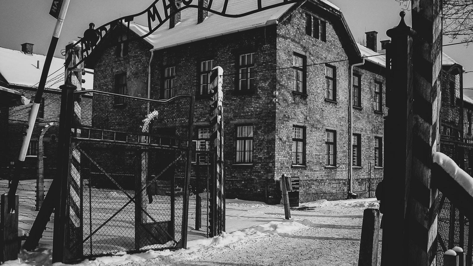 Portão de entrada de Auschwitz com a inscrição em ferro, em preto e branco