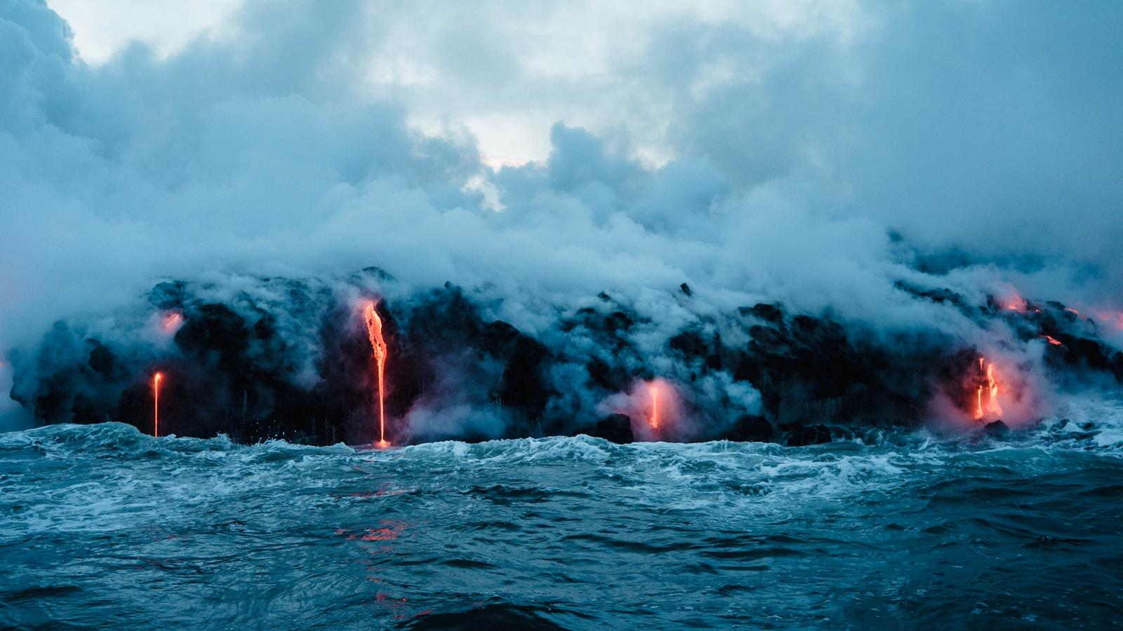 Lava incandescente escorrendo para o mar, com vapor subindo