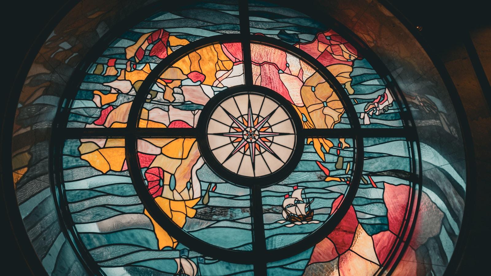 Vitral circular com um mapa-múndi e uma rosa dos ventos ao centro