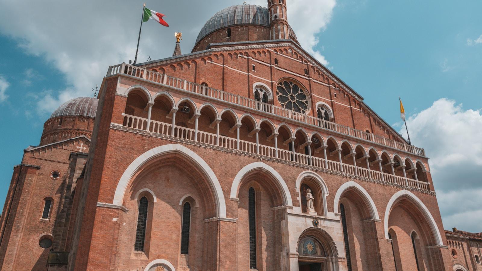 Fachada da Basílica de Santo Antônio, em Pádua, com suas cúpulas e a bandeira italiana