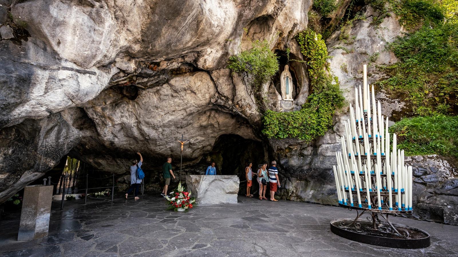 A gruta de Lourdes, com a imagem de Nossa Senhora no nicho da rocha e um candelabro de velas