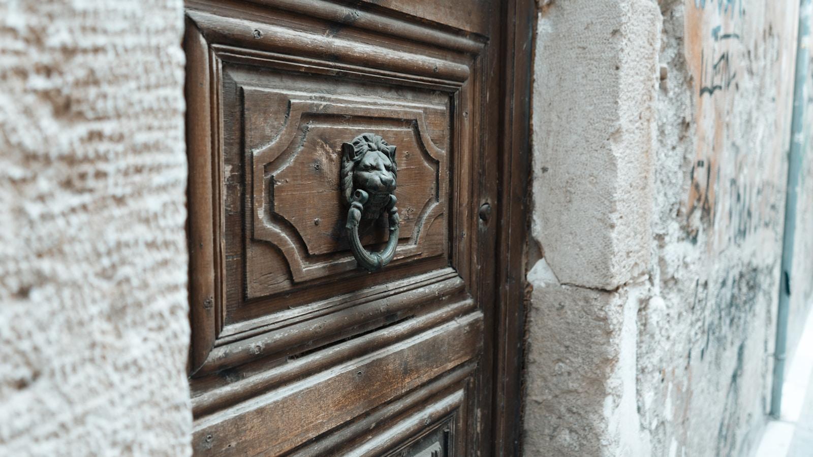 Batedor de bronze em forma de leão numa porta antiga de madeira