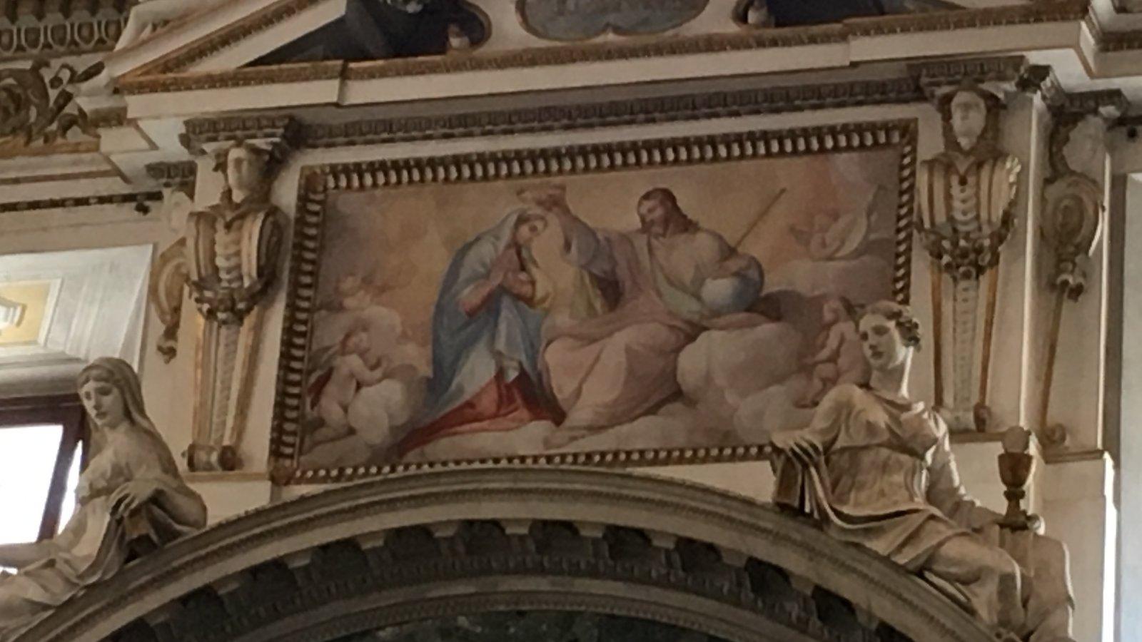 Pintura mariana emoldurada sobre o arco de uma igreja
