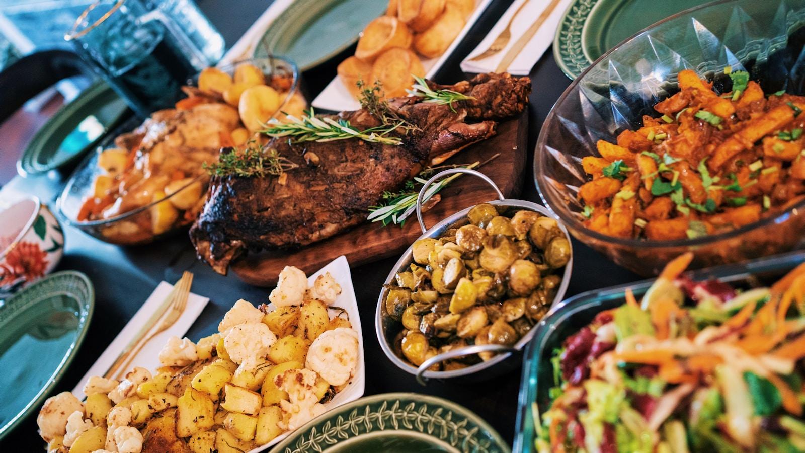 Mesa farta com vários pratos de carne, legumes e saladas