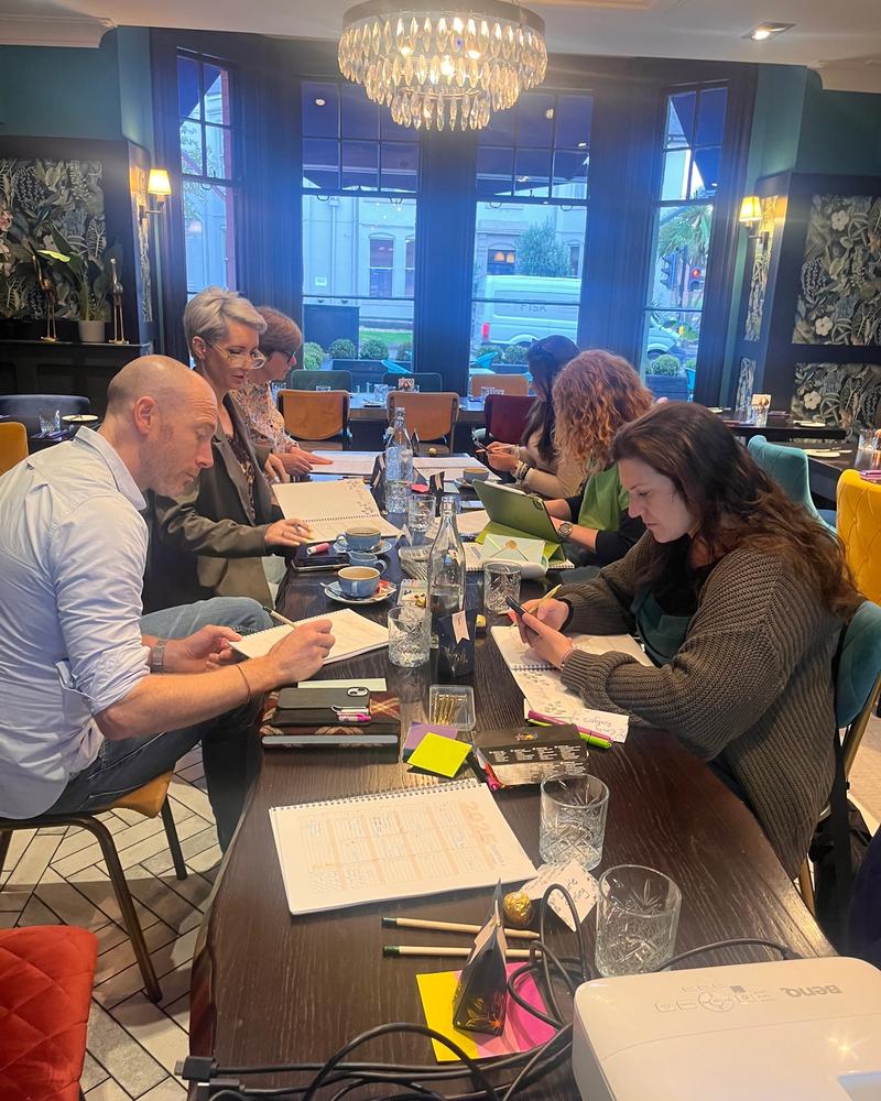 Founders working through their plans around the table at a Boardroom Reset day