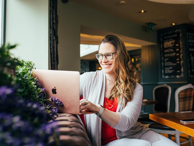 Laurie Stirling smiling while working on her laptop