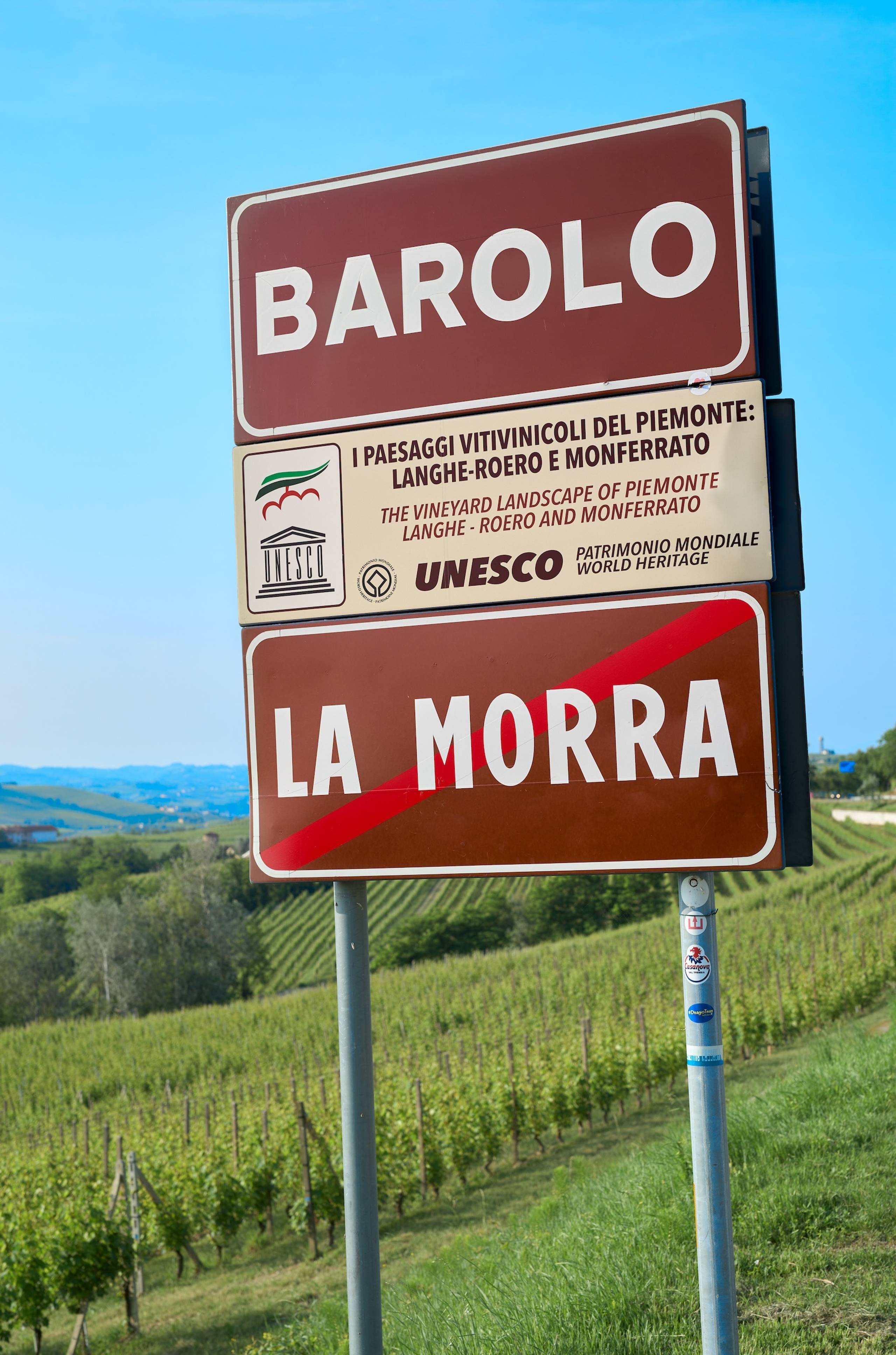 Skiltet som skiller La Morra fra Barolo, der du ser vinmarkene i bakgrunnen i de idylliske området