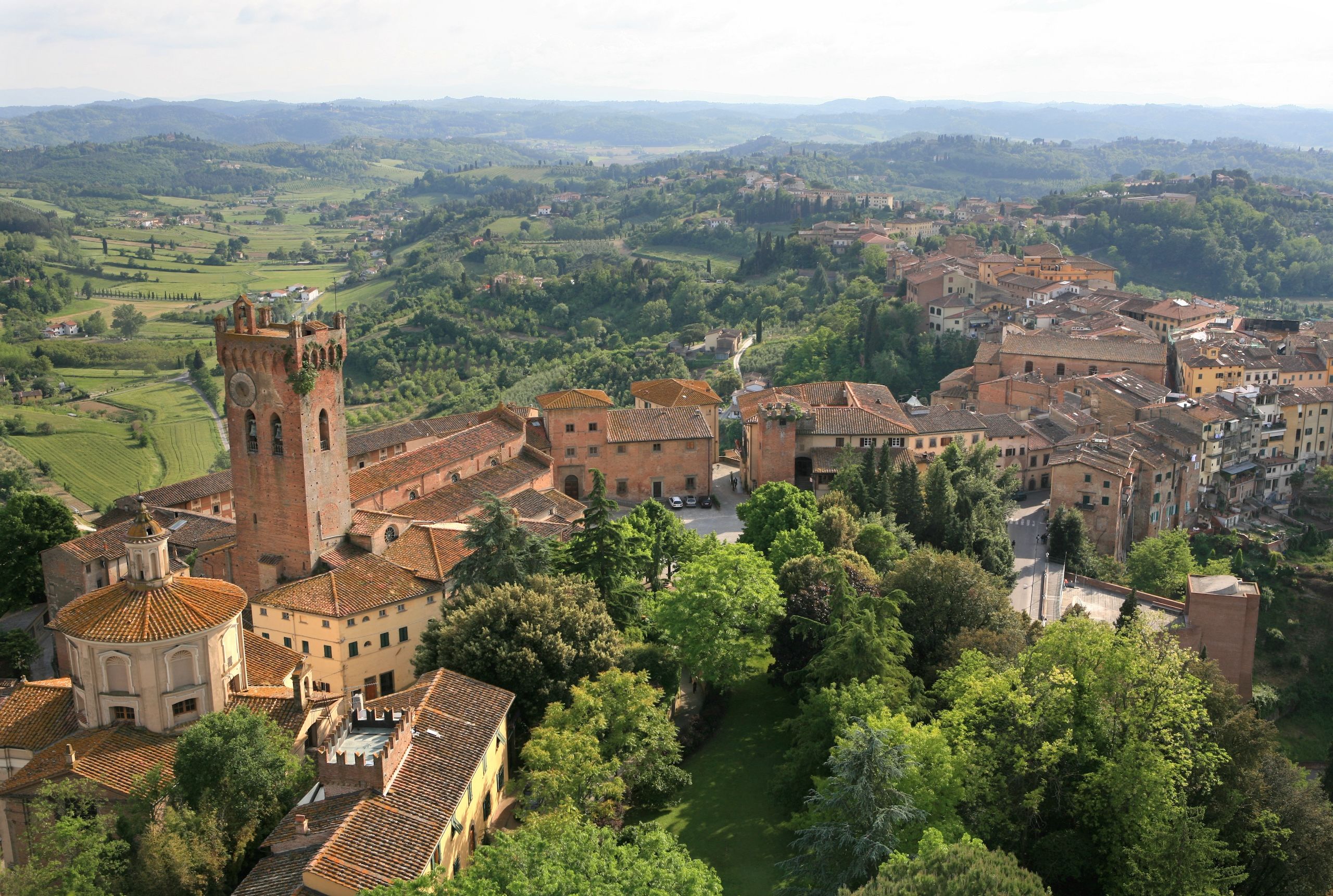 Landsbyen San Miniato med sine middelalderlige tårn, omgitt av frodige toskanske landskap.