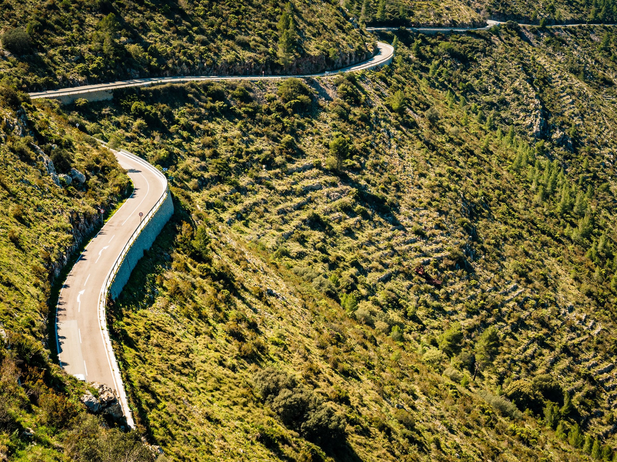 Sykkelvei opp til Coll de Rates, Costa Blanca. Slyngende sykkelvei blant frodig landskap.