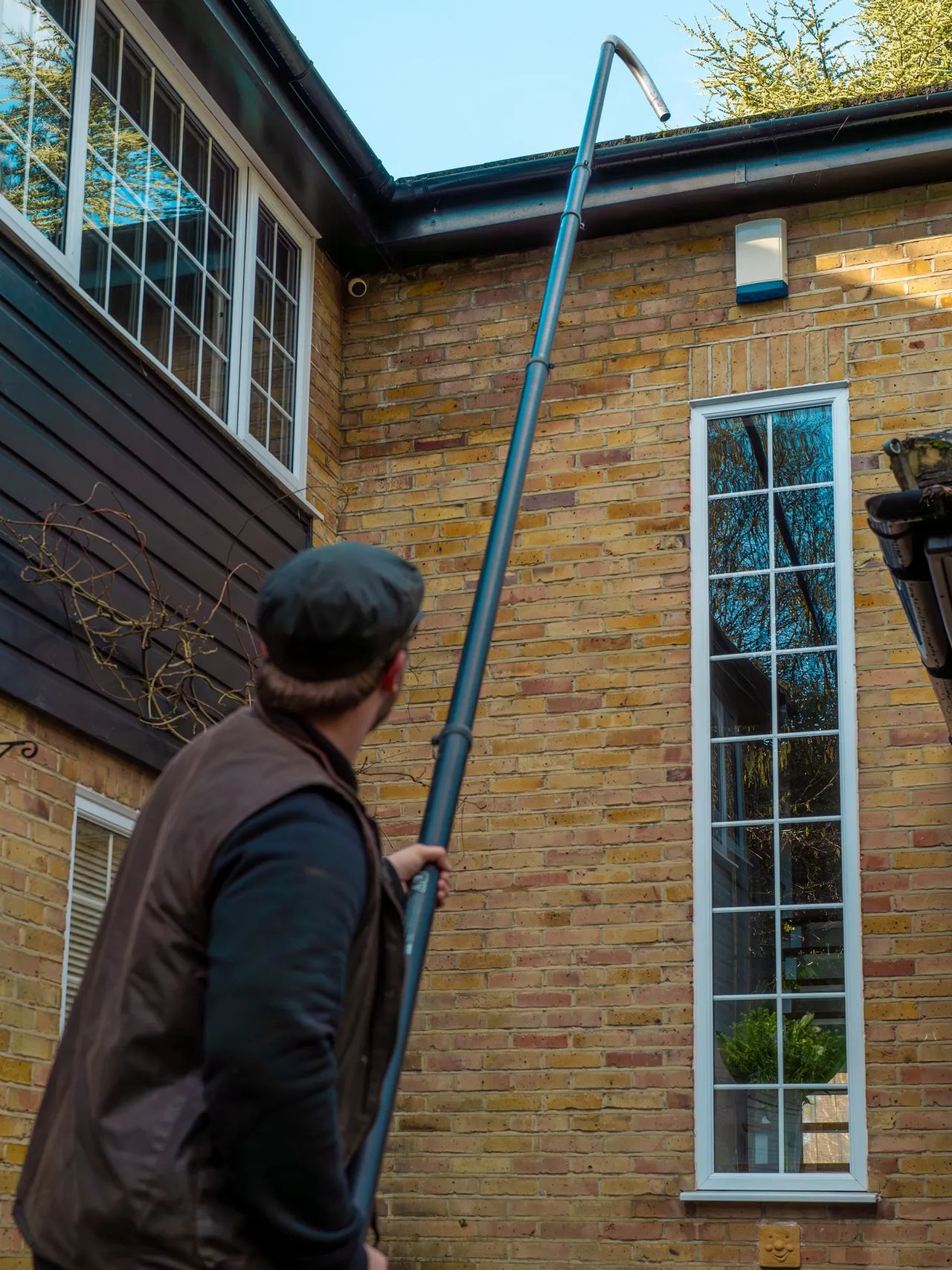 A Willow Alexander team clearing gutters from the ground with a SkyVac, 6