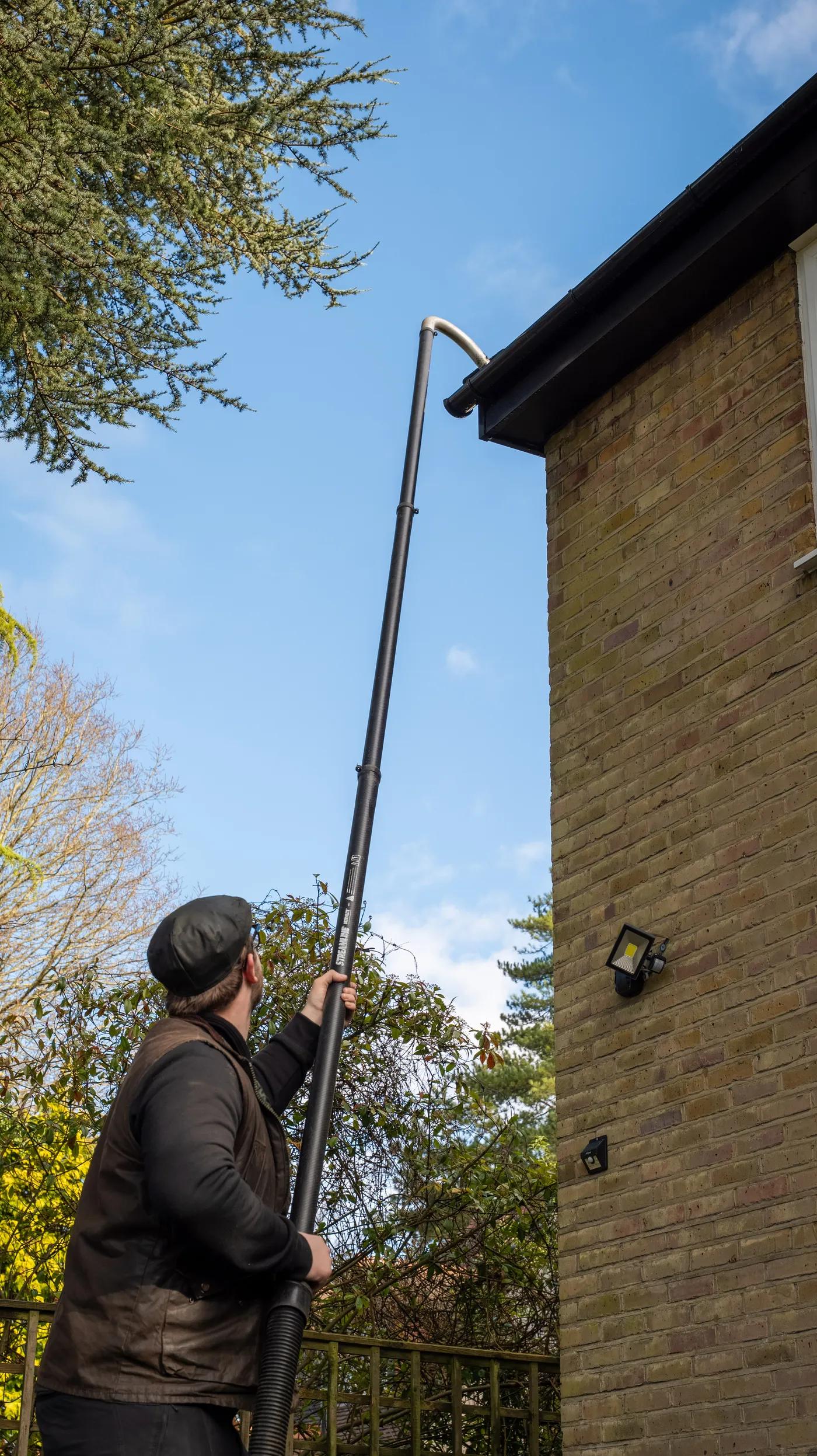 A Willow Alexander team clearing gutters from the ground with a SkyVac, 2
