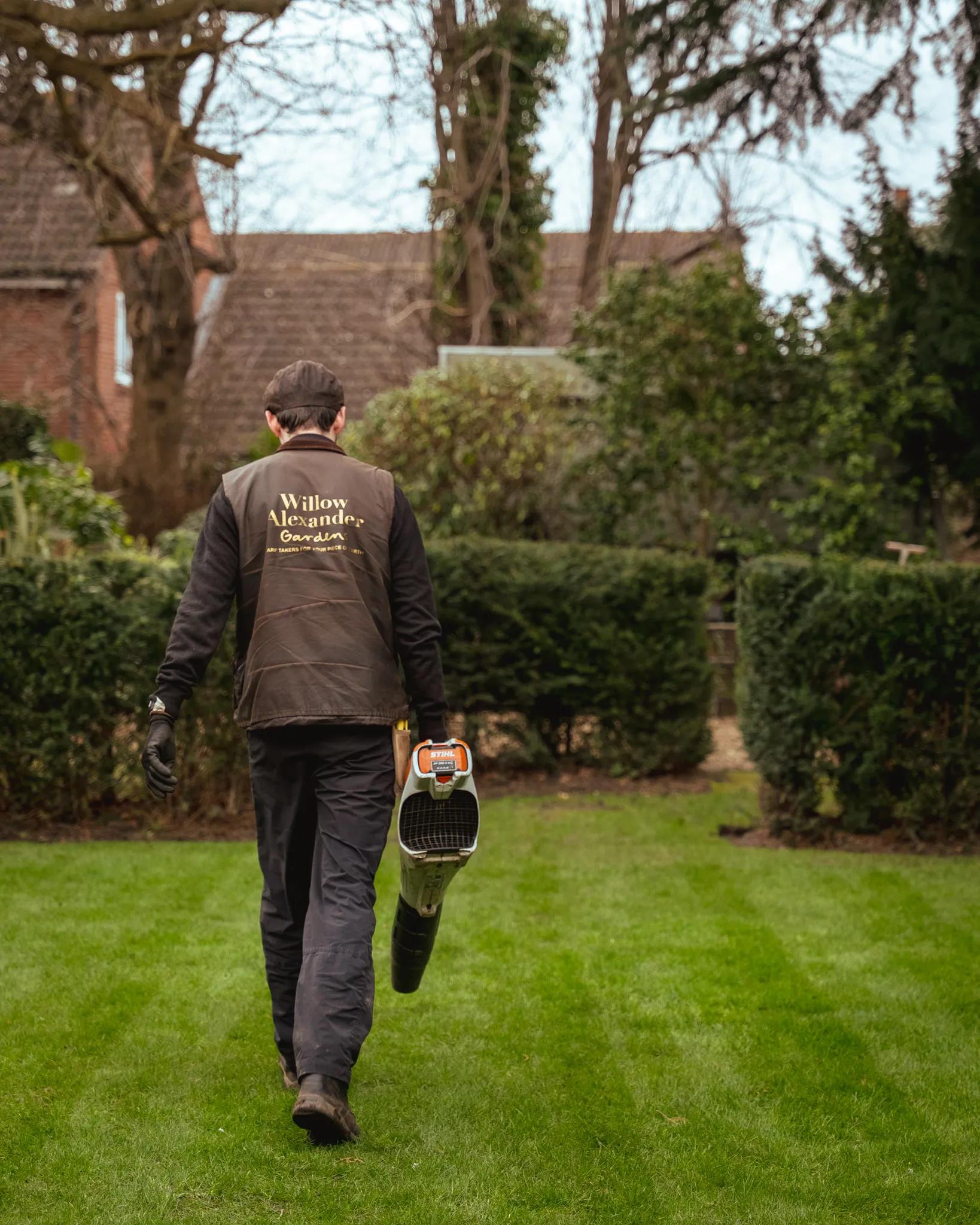 Willow Alexander gardener walking a wide striped lawn at a residential development
