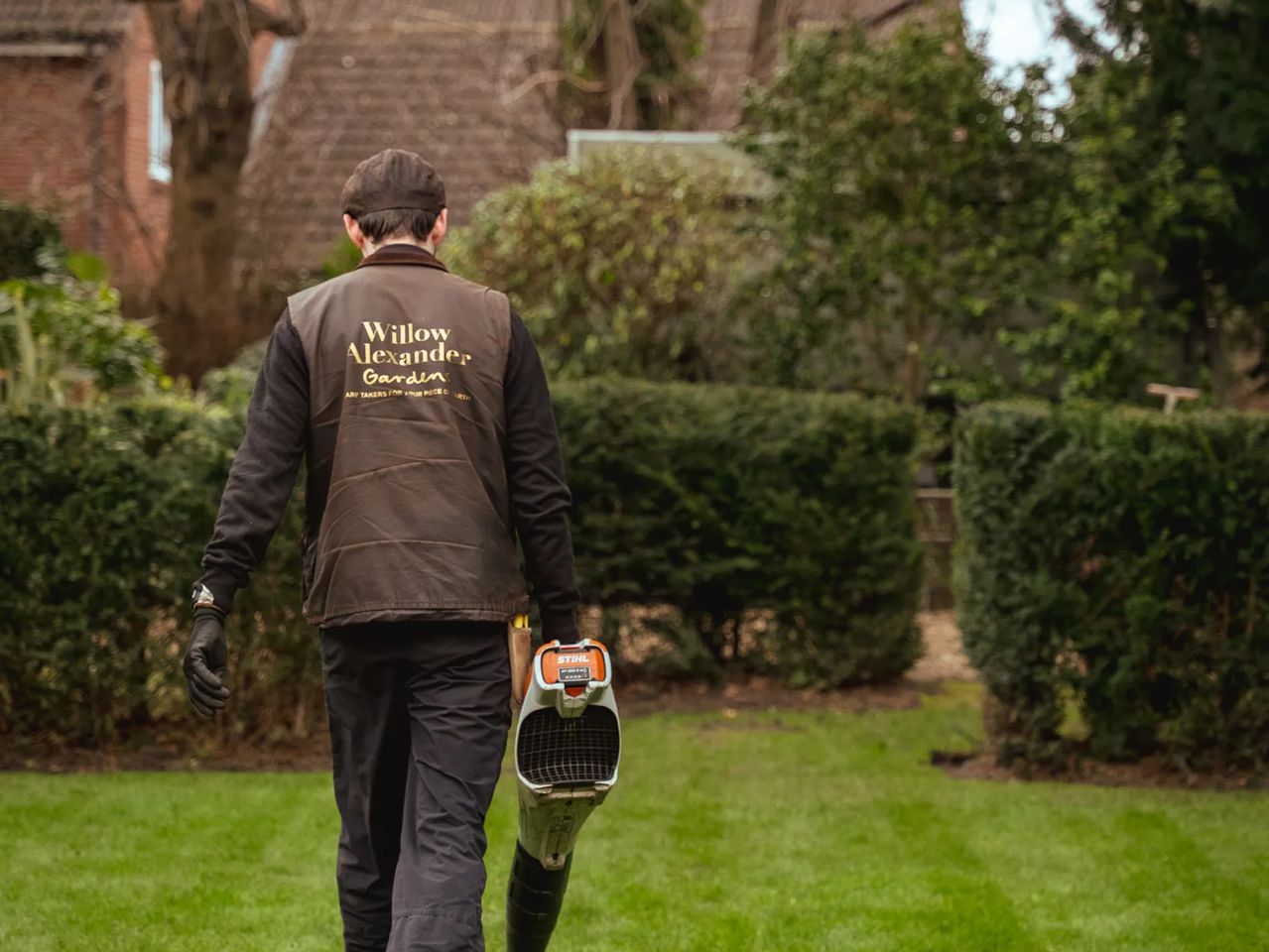 Willow Alexander gardener walking a wide striped lawn at a residential development