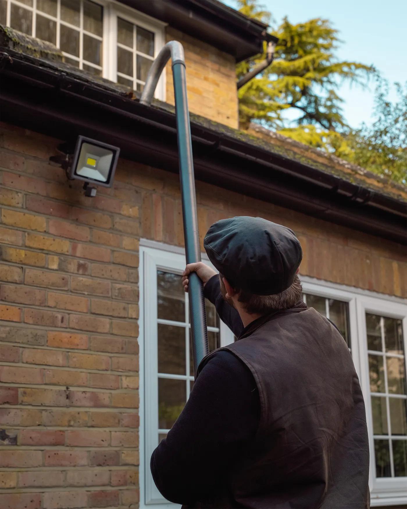 A Willow Alexander team clearing gutters from the ground with a SkyVac, 3