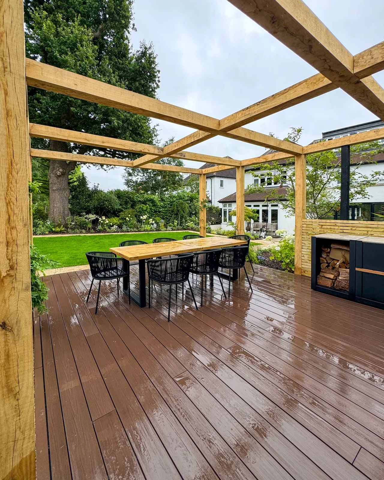 Warm umber composite decking beneath a timber pergola