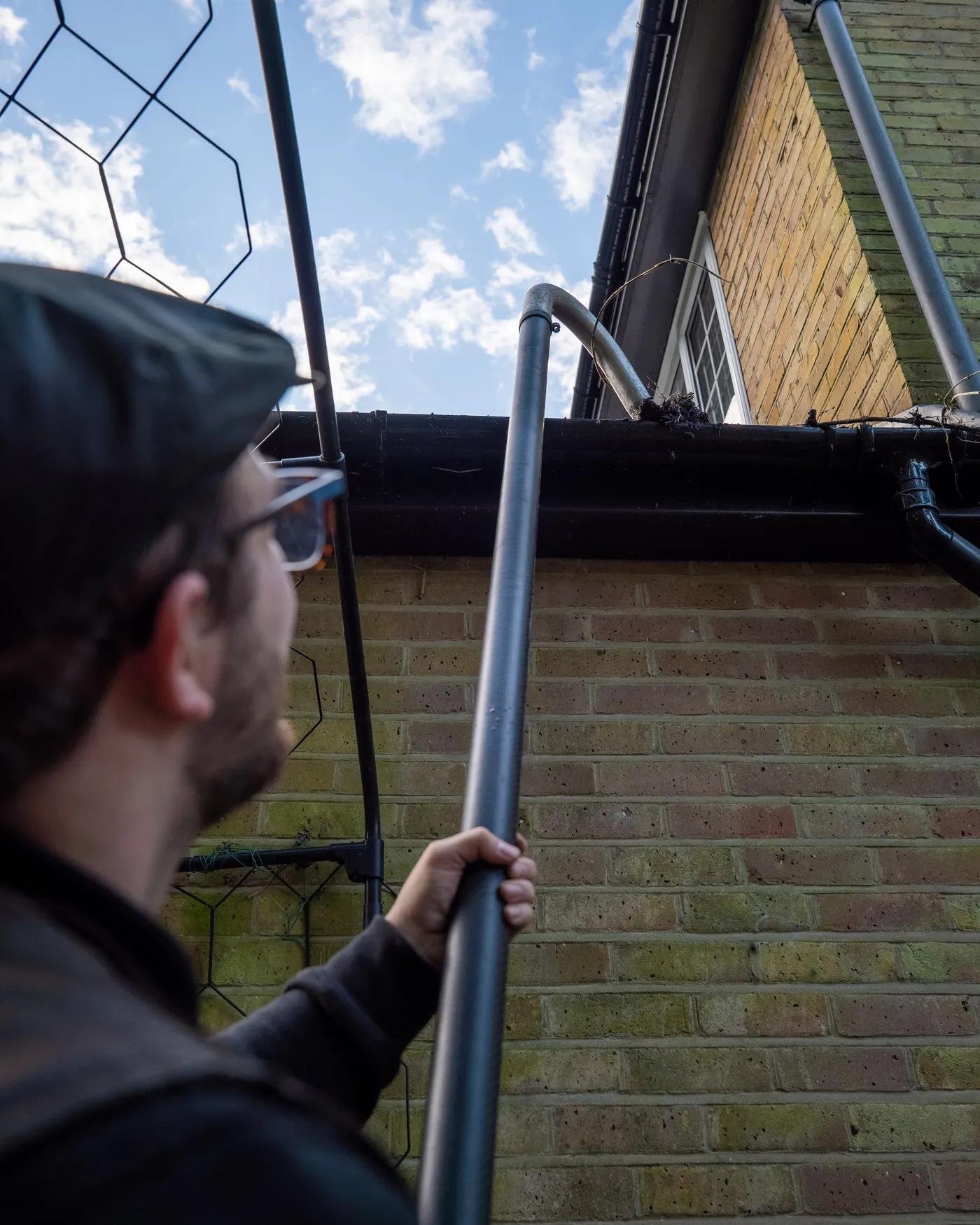 A Willow Alexander team clearing gutters from the ground with a SkyVac, 1