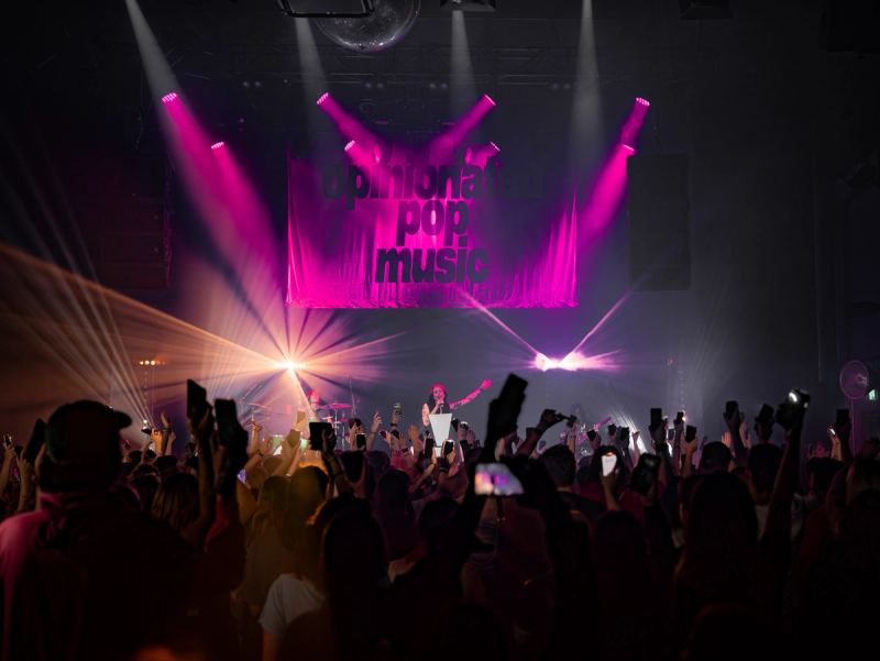 Wide view of Säälchen Berlin with pink stage lights and the crowd's hands in the air