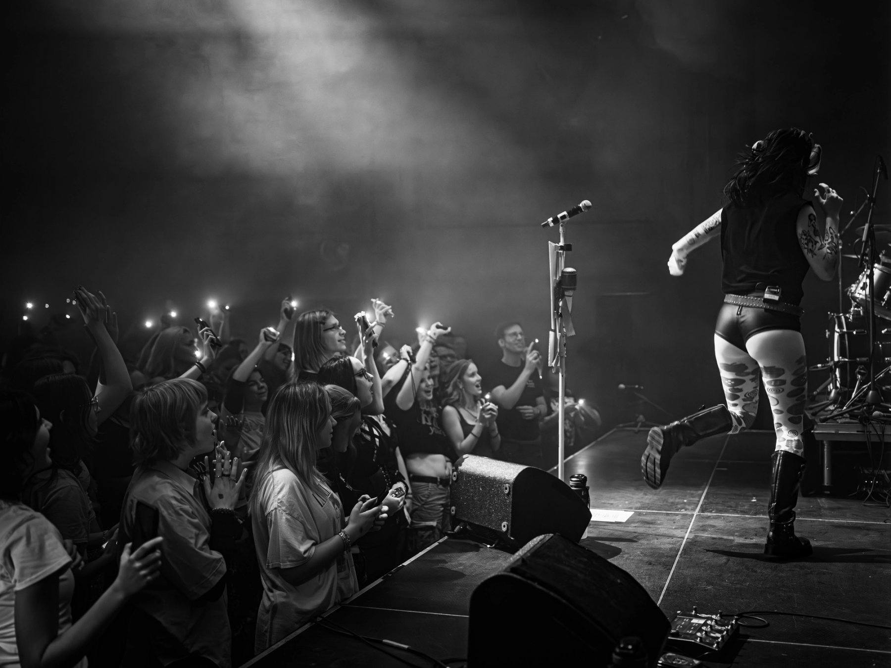 Black and white photo of the crowd filming with phones as Girli performs