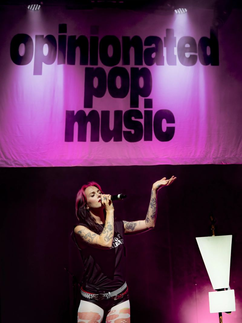 Pink-lit banner reading opinionated pop music on stage at Säälchen Berlin