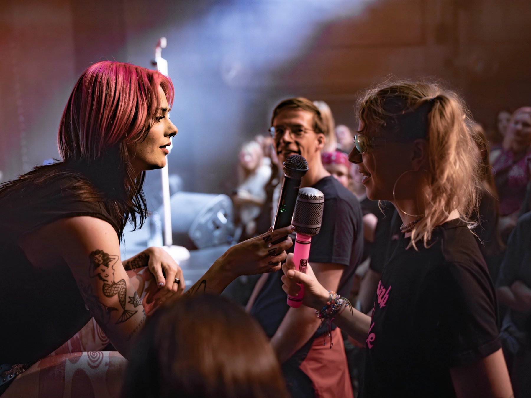 Girli holds a mic to a fan who holds an inflatable pink microphone at Säälchen Berlin
