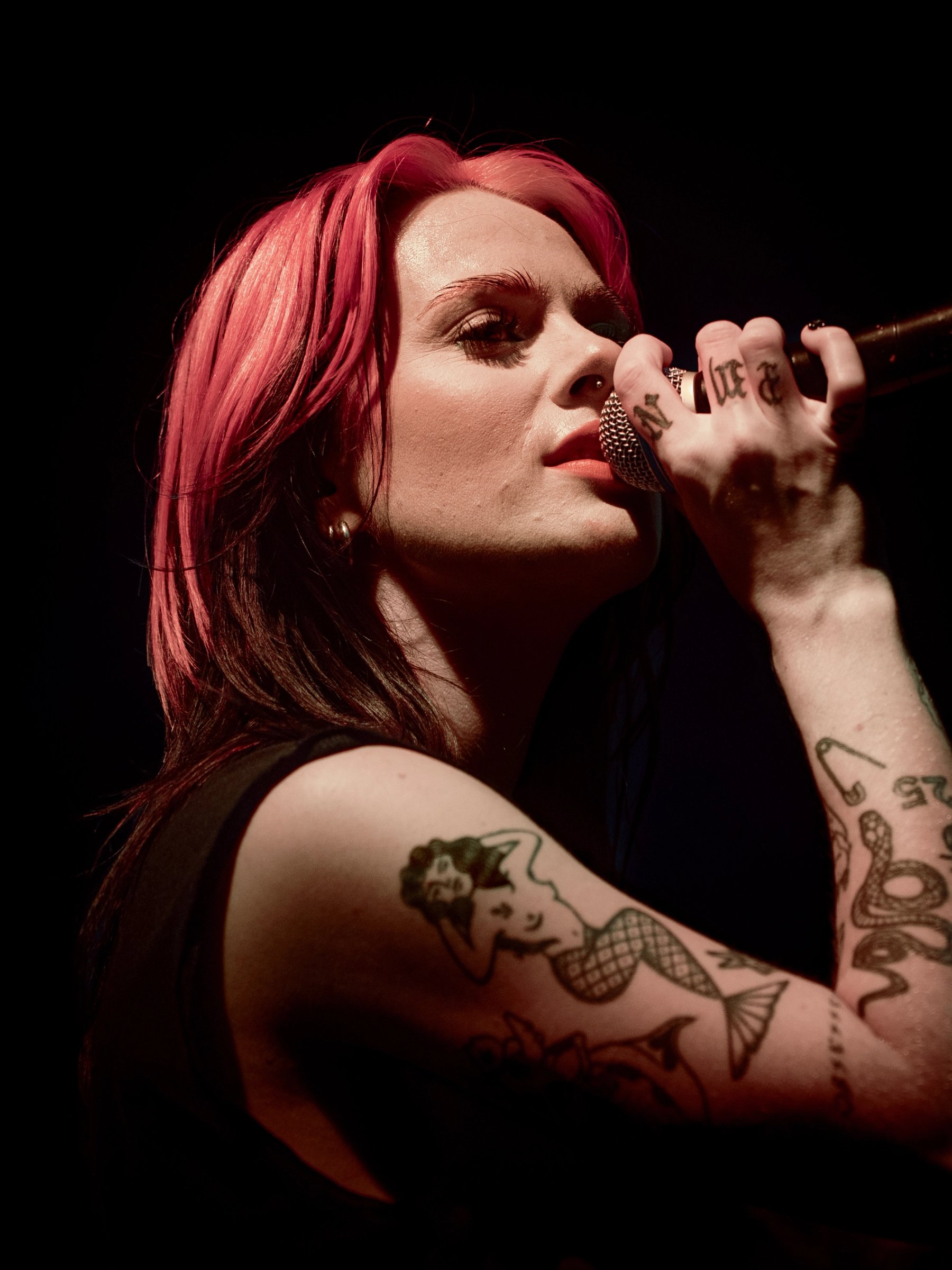 Close-up of Girli singing into a microphone at Säälchen Berlin