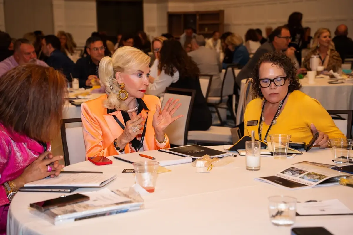 Table of attendees review notes at a round table 