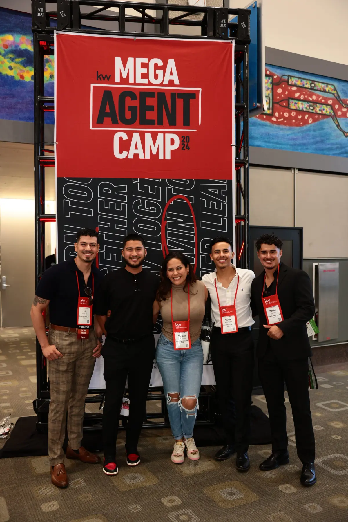 Group of agents posing together in front of the Mega Agent Camp sign