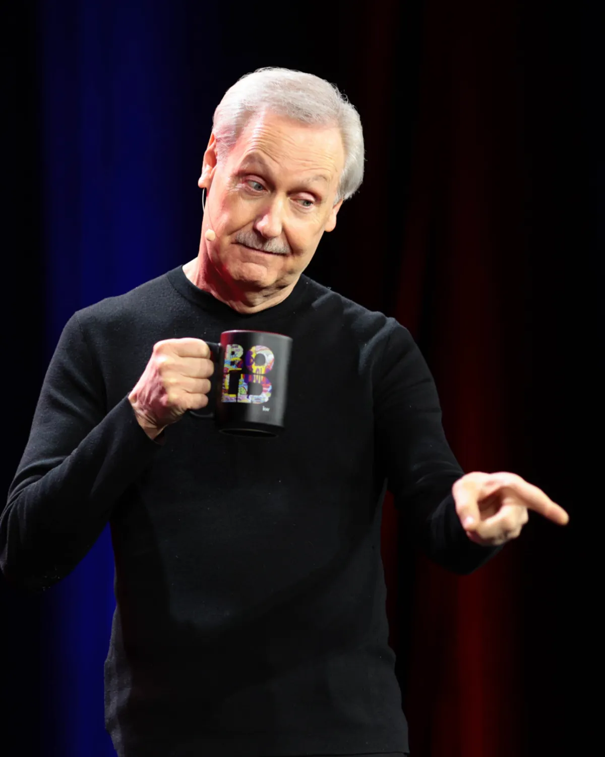 Gary Keller on stage holding a BOLD mug