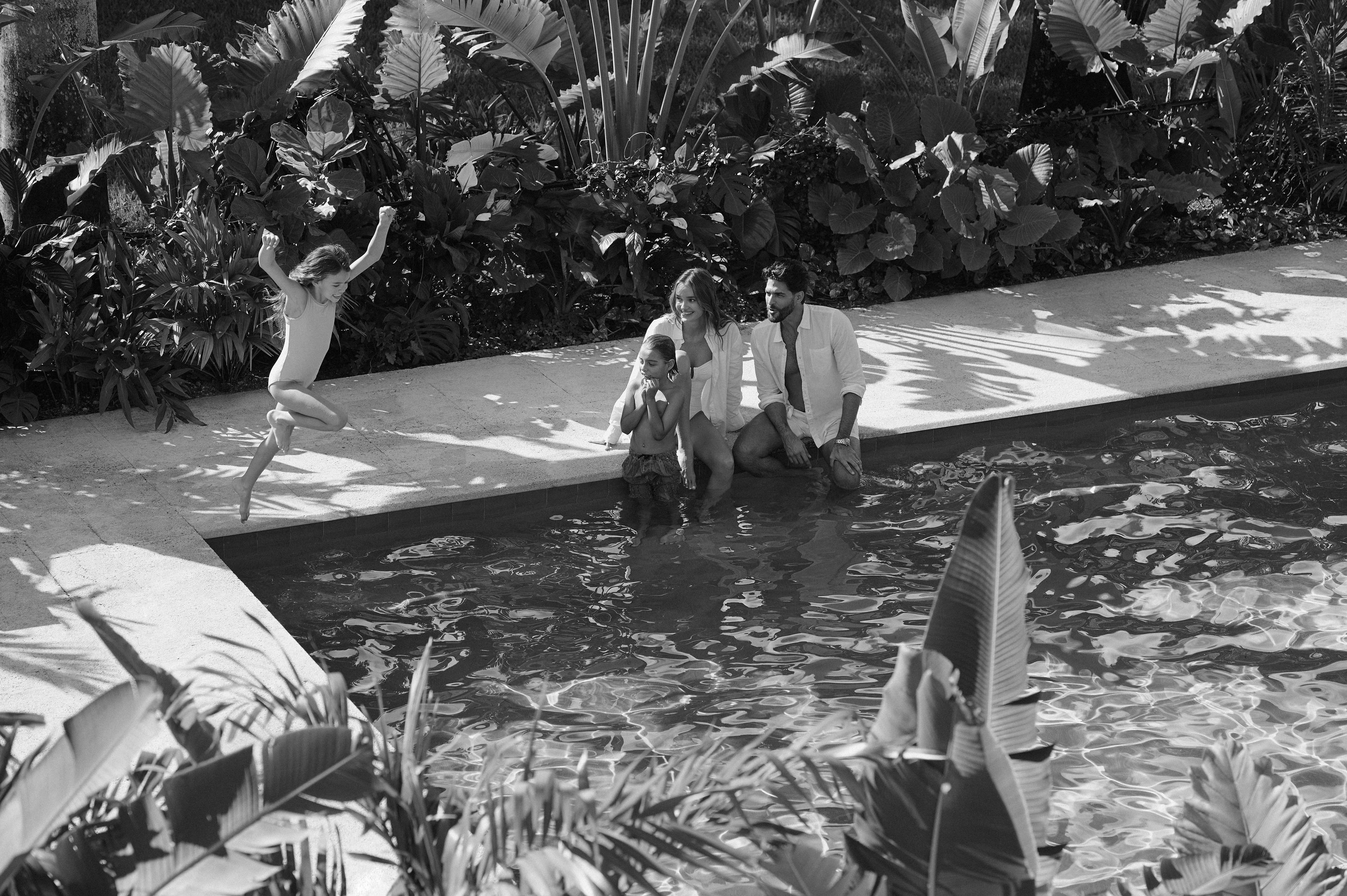 A family of four playing in the pool.