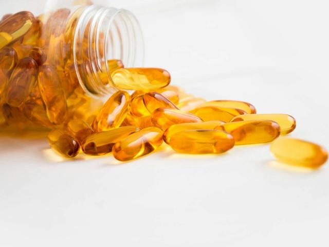 Spilled bottle of yellow capsule pills