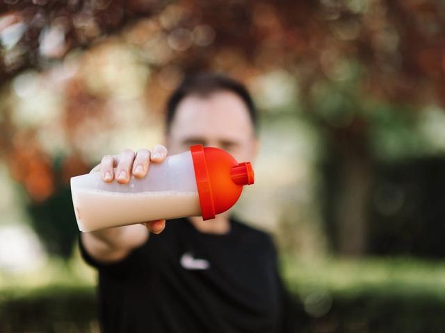 Man holding a protein shaker cup