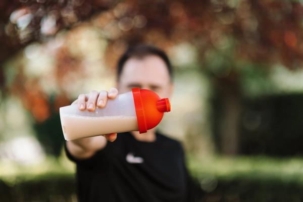Man holding a protein shaker cup